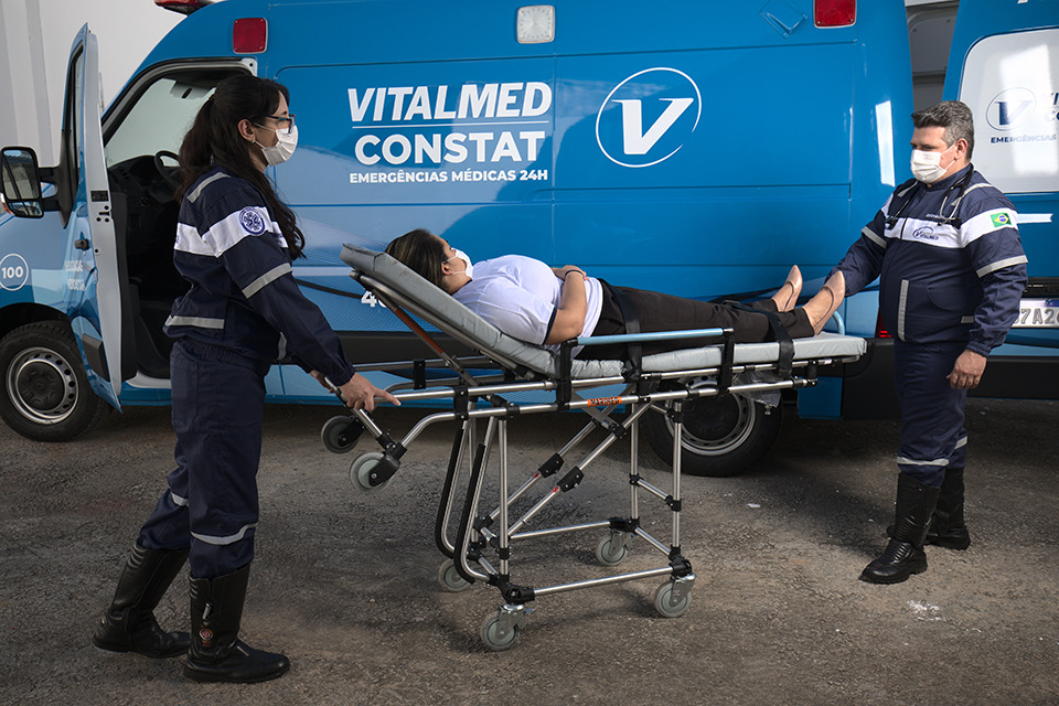 Equipe da Vitalmed Constat com paciente na maca ao lado da ambulância